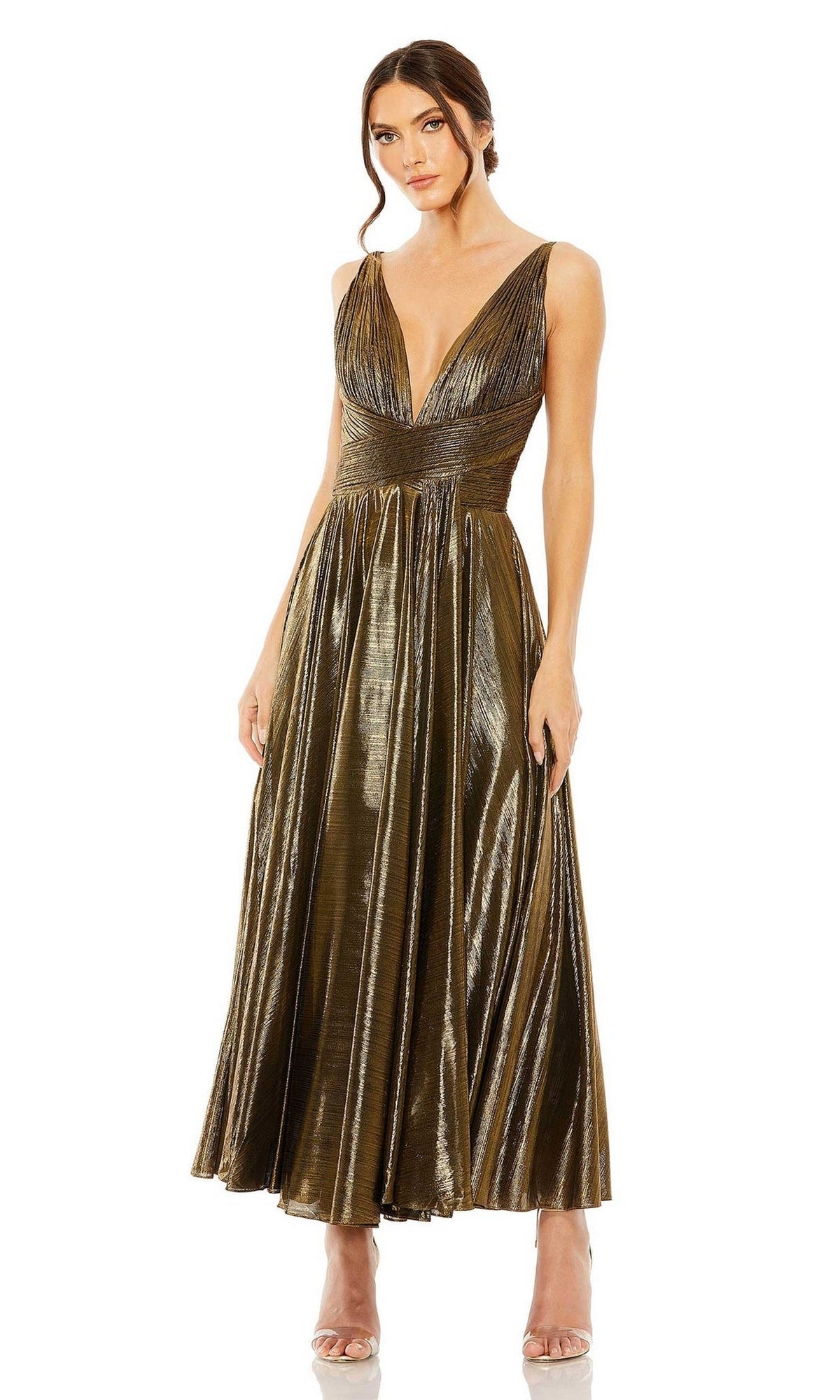 A woman stands with hands by her sides, wearing the Mac Duggal 30761 tea-length wedding-guest dress—sleeveless, metallic bronze, with a deep V-neckline and pleated skirt.